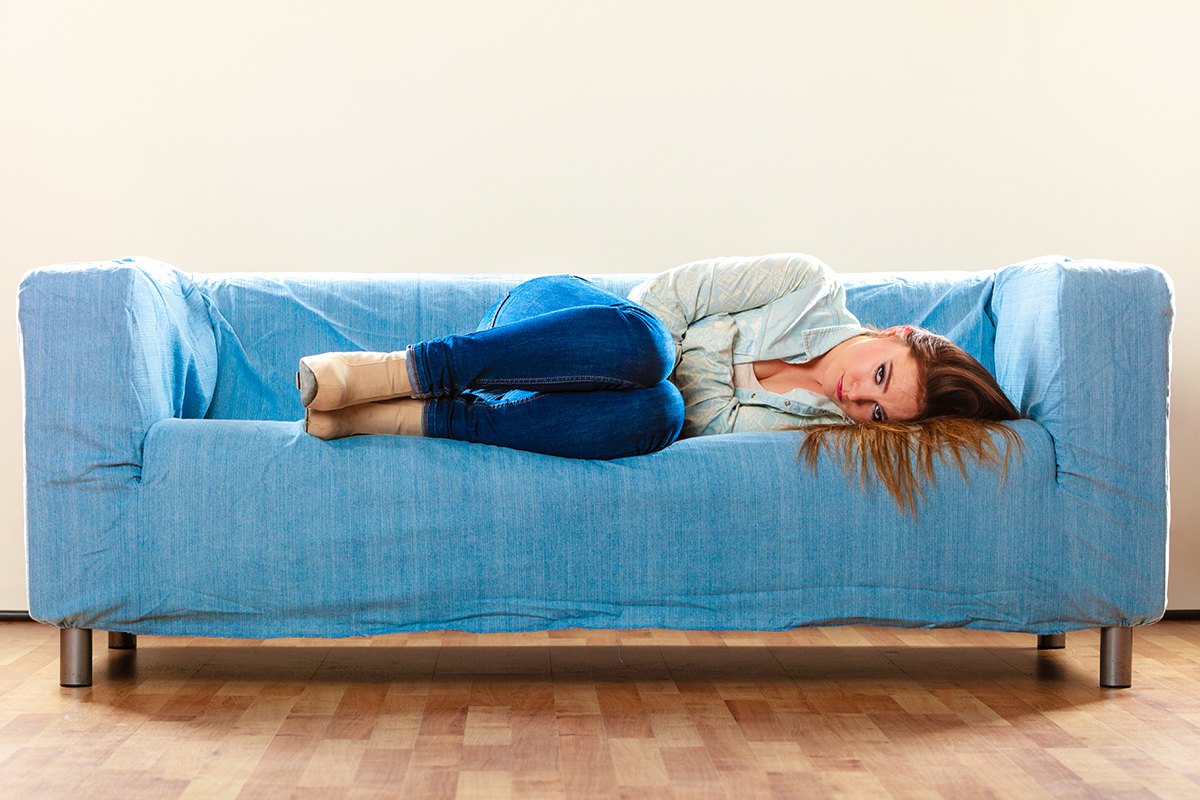 Woman with fibromyalgia laying on a couch